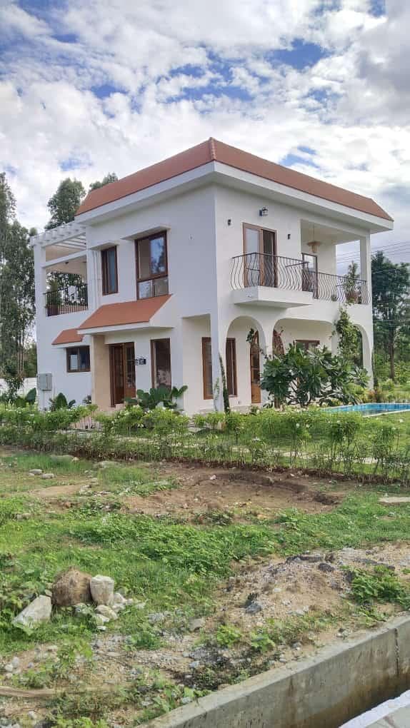 Two-storey villa with a sloped red roof on an open plot, built by ACIPL